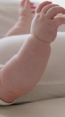 Çıplak, tombul elleri ve ayaklarıyla sırt üstü uzanmış bir bebeğin yan görüntüsü. Aktif çocuk elleriyle ve ayaklarıyla oynuyor. Direk güneş ışınlarından gelen D vitamini. Bebek emziği
