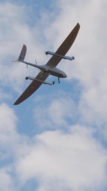 Uçak şeklinde beyaz akıllı dron uçar ve açık mavi gökyüzünde film çeker. Devlet güvenliği için en son model insansız hava aracı taramaları. Yenilikçi teknoloji kavramı