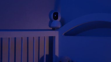 Yatak odasındaki yatak başlığına dijital bebek monitörü yerleştirilmiş. Çevrimiçi teknoloji ebeveynlerin yeni doğan çocuğa bakmasına yardımcı oluyor.