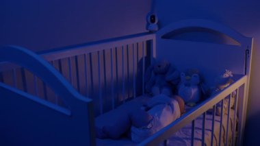 Pofuduklu sağlıklı bir bebek eski model bir karyolada gözetim altında uyur. Karyola tarafına yerleştirilmiş güvenlik kamerası ebeveynlere geceleri huzur sağlıyor