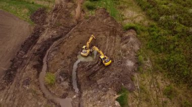 Kazıcılar kırsal alandaki drenaj kanallarını kazarak etkin su akışı için kanal oluşturuyorlar. Çevredeki kırsal bölgede arazi yönetimi