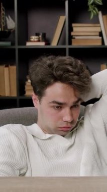 Yorgun öğrenci elleri başının arkasında masa başında oturarak işe ara verir. Adam kütüphanede kitaplığa yaslanıp rahatlıyor. Stresli hissediyor