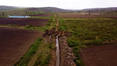 Kazıcılar tarım arazisi boyunca sulama kanalları kazıyorlar. Tarım arazilerini stratejik altyapı geliştirme yoluyla dönüştürmek