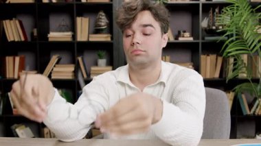 Yorgun öğrenci ev kütüphanesinde saatlerce çalıştıktan ve araştırdıktan sonra gözlüklerini çıkarıyor. Adam göz yorgunluğu ve yorgunluğu yaşıyor.
