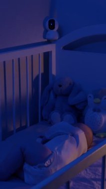 Pofuduklu sağlıklı bir bebek eski model bir karyolada gözetim altında uyur. Karyola tarafına yerleştirilmiş güvenlik kamerası ebeveynlere geceleri huzur sağlıyor