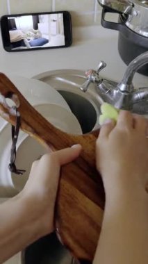 Ev hanımı bulaşıkları yıkıyor ve mutfaktaki akıllı telefondan dadı kamerası görüntülerini izliyor. Anne, yeni doğan bebeği evde angarya işleri yaparken kontrol ediyor.