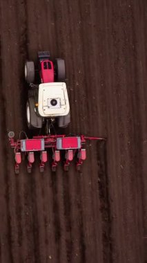 Çekici, ekiciyi üniformalı kahverengi alanda kendine has çizgiler bırakarak çeker. Uzun koyu gölgeler, yüksek güneş pozisyonunu çapraz olarak gösterir.