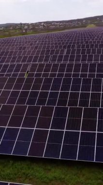 Sıralar halinde dizilmiş güneş panelleri yeşil alan hava görüntüsünde güneş ışığını yakalar. İstasyon, kırsal kesimde daha parlak bir gelecek için sürdürülebilir enerji üretir