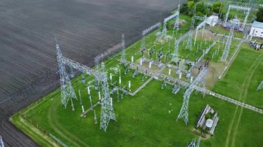 Yüksek voltajlı elektrik hatları ve yeşil alanlarla çevrili alt istasyonları olan ulusal elektrik ağının hava perspektifi, enerji dağıtım altyapısını gösteriyor