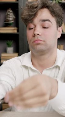 Yorgun öğrenci ev kütüphanesinde saatlerce çalıştıktan ve araştırdıktan sonra gözlüklerini çıkarıyor. Adam göz yorgunluğu ve yorgunluğu yaşıyor.