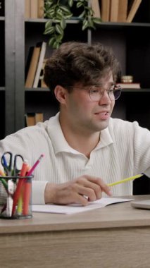 Genç adam evde sanal sınıfa aktif olarak katılıyor. Brunet, rahat ortamda dizüstü bilgisayarla ilgili dersler alıyor.