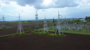 Açık alanlar ve dramatik bulutlarla çevrili, elektrik hatları ve iletim kuleleri, günlük faaliyetler için elektrik altyapısına olan bağımlılığı gözler önüne seriyor.