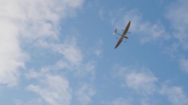 İHA açık mavi gökyüzüne karşı uçarken yakalandı, modern tasarım ve yeteneklerini vurgulayarak, teknoloji ve hava keşiflerindeki gelişmeleri temsil ediyor.