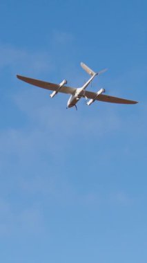 Uçak, parlak mavi gökyüzüne karşı yüksekten uçuyor. Aerodinamik şeklini ve gelişmiş mühendisliğini vurguluyor. Havacılık ve teknolojideki ilerlemeyi simgeliyor.