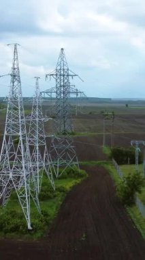 Enerji dağıtımı için gerekli altyapıyı gösteren elektrik hatları ve alt istasyonlarla çevrili uzun elektrik nakil kuleleri manzaraya hakim.