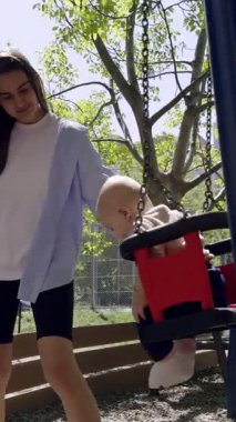 Kız canlı bir parkta salıncakta sallanıyor, güneş ışığı yaprakların arasından süzülüyor, açık havada neşe ve eğlence ortamı yaratıyor.