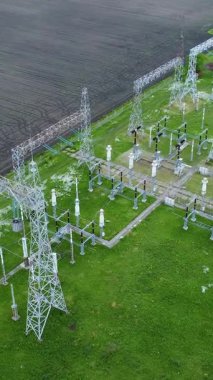 Yüksek voltajlı elektrik hatları ve yeşil alanlarla çevrili alt istasyonları olan ulusal elektrik ağının hava perspektifi, enerji dağıtım altyapısını gösteriyor