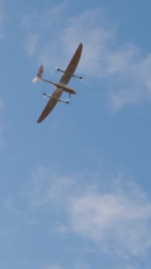 İHA açık mavi gökyüzüne karşı uçarken yakalandı, modern tasarım ve yeteneklerini vurgulayarak, teknoloji ve hava keşiflerindeki gelişmeleri temsil ediyor.