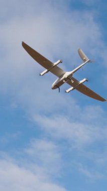 Parlak mavi gökyüzünde süzülen hava aracı modern tasarımı ve özelliklerini vurgulayarak teknoloji ve fotoğrafçılıktaki gelişmeleri sembolize ediyor.