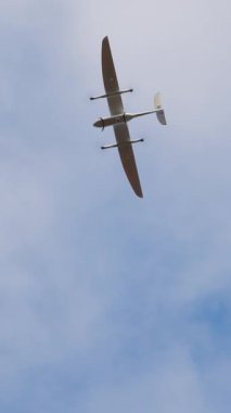 Açık mavi gökyüzünde uçan küçük bir uçak, onun aerodinamik şeklini ve kanat açıklığını vurguluyor, özgürlük ve keşif duygularını uyandırıyor.