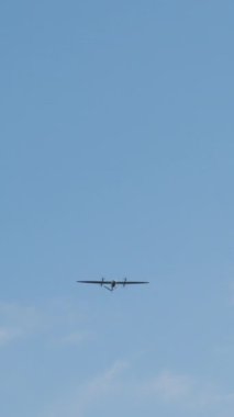 Parlak mavi gökyüzünde süzülen küçük bir uçak. Aerodinamik şeklini ve mühendisliğini ön plana çıkarıyor. Havacılık ve keşif ruhunu somutlaştırıyor.