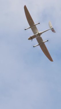 İnsansız hava aracı gökyüzünde yükseklere uçuyor, modern tasarım ve becerilerini gösteriyor, çarpıcı hava perspektiflerini yakalıyor ve alandaki teknolojik gelişmeleri gösteriyor.