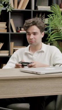 Ofis malzemeleri ve klasörlerle çevrili, elleri masa başında oyun oynayan bir adam. Rahatlamış atmosfer gelişigüzel aktiviteler gösteriyor.