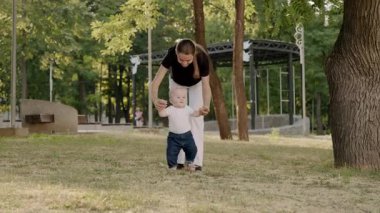 Bebeğin ilk adımları anne tarafından desteklenirken, erken gelişimin özünü yakalar ve sevgi ve cesaret bağını yakalar.