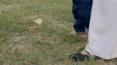 Bebek, annesinin rehberliğiyle ilk adımı atar. Doğa ile çevrili sakin bir açık havada yürümeyi öğrenmenin verdiği heyecan ve bağın altını çizer.