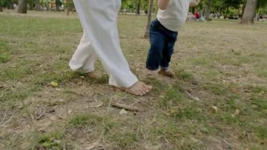 Bebek, çimenli bir parkta annelerle ilk adımı atıyor. Yeni hareketin heyecanını ve aile bağlarının sıcaklığını gösteriyor.