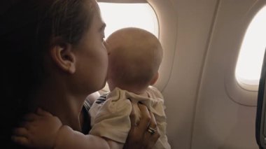 Anne ve bebek, uçağın penceresinin kenarında paylaşılan bir anın tadını çıkarıyorlar. Yolculuğun ve gökyüzünün güzelliğinin tadını çıkarıyorlar. Yürek ısıtan bir sahne yaratıyorlar.