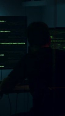 Karanlık bir odada, yeşil metinlerle aydınlatılmış, yüksek teknolojili bir konsantrasyon ve dijital keşif atmosferi yaratan, birden fazla ekranda veri analizi yapan kişi.