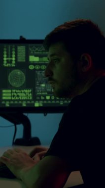 Veri analisti, çağdaş bir çalışma alanında yeşil kod ve dijital verilerle dolu ikili ekranlar üzerinde yoğunlaştı ve veri analiz araştırmalarının karmaşıklıklarını gözler önüne serdi.