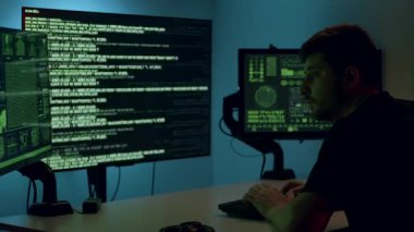 Veri analisti, çağdaş bir çalışma alanında yeşil kod ve dijital verilerle dolu ikili ekranlar üzerinde yoğunlaştı ve veri analiz araştırmalarının karmaşıklıklarını gözler önüne serdi.