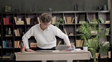 Genç bir uzman gelir ve bir ofis masasına oturur. Çok çalışmak için iyi bir ruh hali içindedir. Bilgisayar gözlüklü çocuk yeni bir gün için iş yerini hazırlıyor.