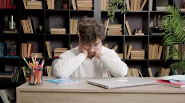 Yorgun genç adam çalışmaya ara verir, gözlerini ve ellerini dinlendirir ve boynunu uzatır. Öğrenim dönemi, dersler, sınavlar öğrenciler için çok zahmetli. Öğrenim kavramı, üniversite, öğrenciler