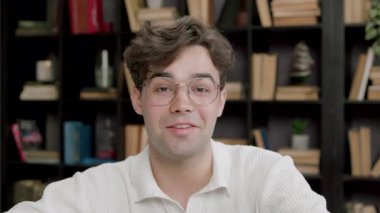 Koruyucu gözlüklü yakışıklı çocuk kameraya bakıyor. Kameraya odaklanmış genç adam elleriyle işaret ederek fikrini, görüşünü, projesini sunuyor.