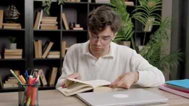 Öğrenci çocuk çalışmalara daldı, ödevlerini yaptı, üniversiteye kabul için hazırlandı, masada oturdu, online öğrenim için dizüstü bilgisayarını kullandı, yeni bilgiler edindi, İngilizce becerilerini geliştirdi..