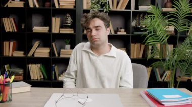 Oğlan omuzlarını uzatır, yazmaktan elleri ağrır ve uzun süre sandalyede oturur. Öğrenci çok fazla öğrenme ve çalışmadan yorgun ve yorgun. Kendini adamış öğrencilerin kavramı 