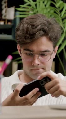 Konsantre ve odaklanmış genç çocuk okul arasında boş zamanlarında modern bir telefonla online oyunlar oynuyor. Çocuk en son aletleri eğlence için kullanıyor.