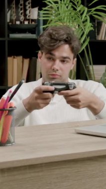 Öğrenci çocuk, teneffüsler arasında üniversitede bankta oturup playstation oynuyor. Genç çocuk online oyunlar için uzaktan kumandayı elinde tutuyor ve boş zamanlarında yeniden yaratıyor.