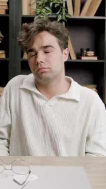 Oğlan omuzlarını uzatır, yazmaktan elleri ağrır ve uzun süre sandalyede oturur. Öğrenci çok fazla öğrenme ve çalışmadan yorgun ve yorgun. Kendini adamış öğrencilerin kavramı 