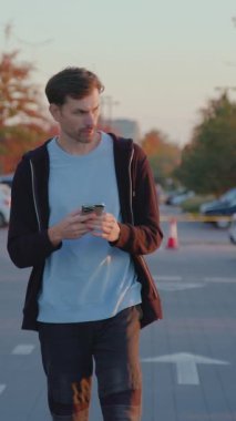 Şehir otoparkındaki kiralık araca erişmek için akıllı telefon uygulaması ile bireysel etkileşimler, modern araba kiralama hizmetlerinin kolaylığını vurguluyor