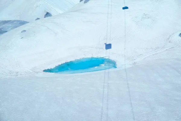 Vermiglio 'da güzel bir turkuaz havuz geniş beyaz bir kar örtüsüyle çevrilidir. Bu büyüleyici kış sahnesi parlak su ve donmuş arazi arasındaki zıtlığı gözler önüne seriyor..