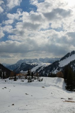 Aschau im Chiemgau 'da sakin bir kış manzarası karla kaplı dağları ve büyüleyici bir kulübeyi gözler önüne seriyor. Gökyüzü bulutlu, bu Bavyera ortamında huzurlu bir atmosfer yaratıyor..