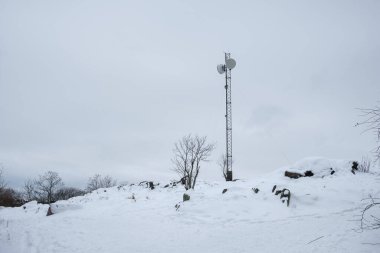 Sessiz bir kış günü, İsveç 'in Stockholm şehrinde kar zemini örtüyor. Çıplak ağaçlar ve kayalık çıkıntılarla çevrili sert manzaranın ortasında bir iletişim kulesi yüksekte duruyor..