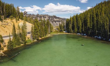 Oregon, Devils Gölü 'ndeki kanocu. Kıyılarda kar var. Algae 'den Yeşil Göl. Drone fotoğrafı.
