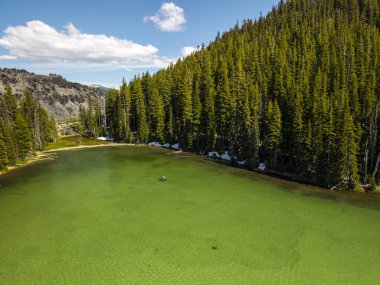 Oregon, Devils Gölü 'ndeki kanocu. Kıyılarda kar var. Algae 'den Yeşil Göl. Drone fotoğrafı.