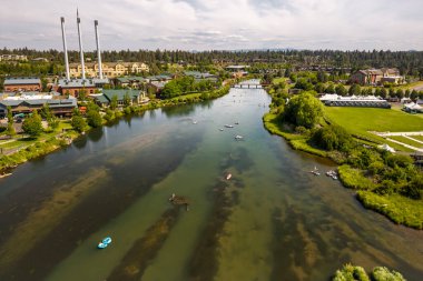 15 Haziran 2025, Bend, Oregon, ABD. İnsanlar, Deschutes Nehri 'nin Eski Değirmen Bölgesi' nden akan bu tembel öğleden sonranın tadını çıkarıyorlar. Drone görünümü.