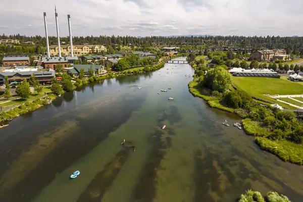 15 Haziran 2025, Bend, Oregon, ABD. İnsanlar, Deschutes Nehri 'nin Eski Değirmen Bölgesi' nden akan bu tembel öğleden sonranın tadını çıkarıyorlar. Drone görünümü.